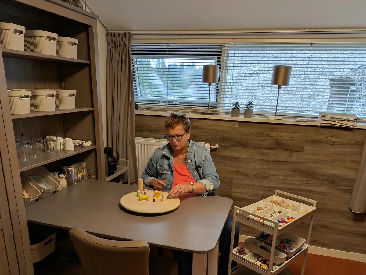 Tafelopstelling met houten figuren tijdens een familieopstelling in Musselkanaal, Groningen